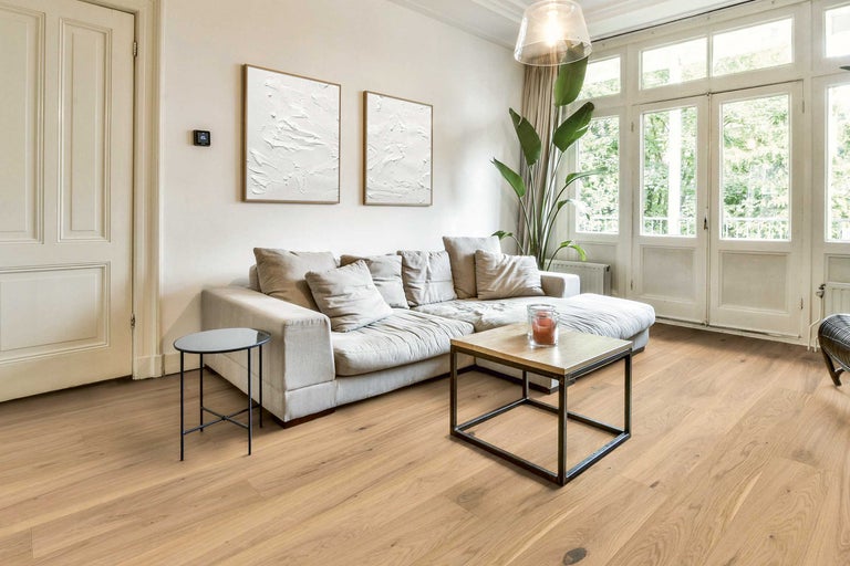 Wohnzimmer mit Sofa, Tischen und Holzboden