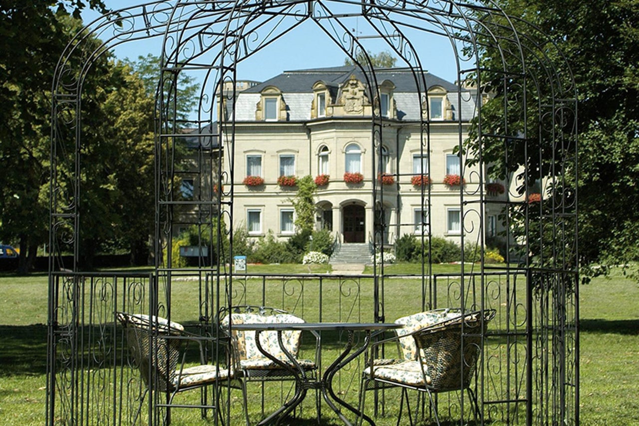 Metallpavillon mit Tisch und Stühlen im Garten