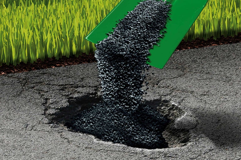 Szene einer Asphaltoberfläche mit einem Loch, das mit Asphaltgranulat aufgefüllt wird