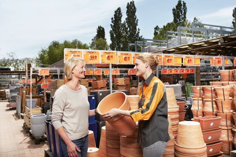 Kundin und Hornbach Mitarbeiterin mit Blumentopf im Hornbach Markt