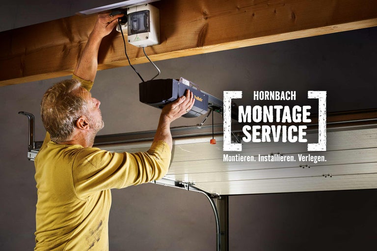 Ein Handwerker installiert einen Garagentorantrieb. Hornbach Montageservice