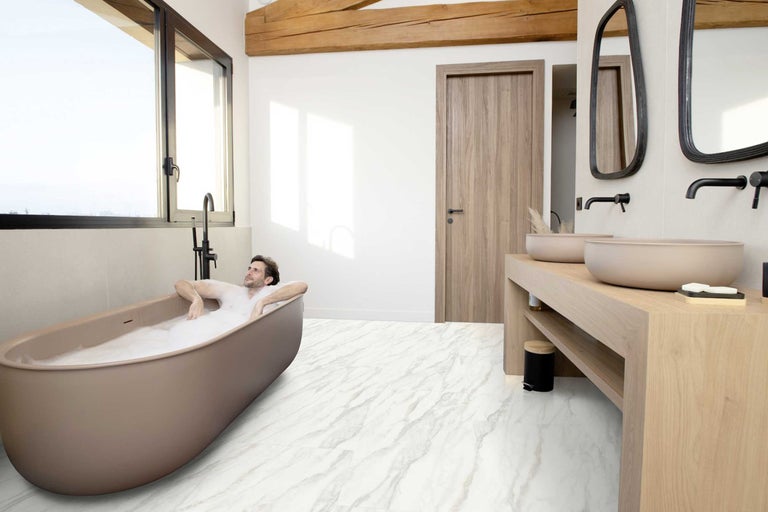 Badezimmer mit freistehender Badewanne, Waschtisch und Marmorboden