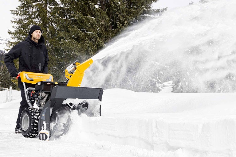Mann benutzt eine Schneefräse von Stiga zum Schneeräumen