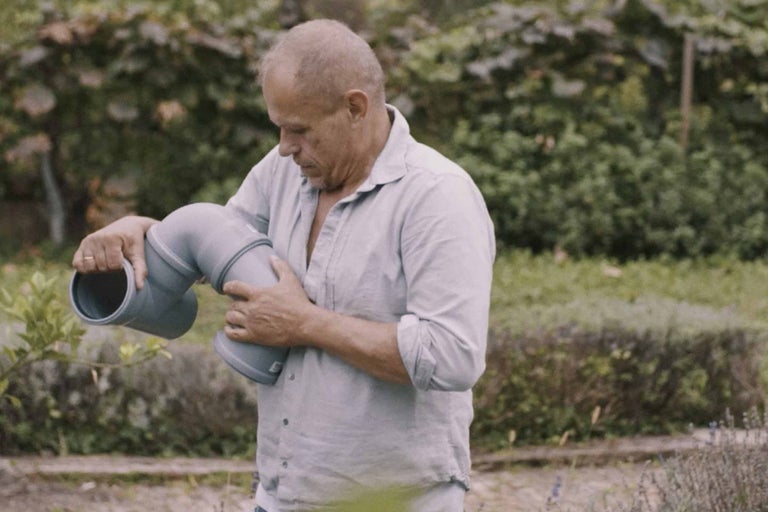 Ein Mann hält ein Abwasserrohr in der Hand, das für Sanitärinstallationen geeignet ist.