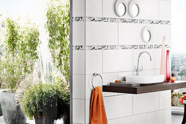 Badezimmer mit weißen Fliesen, Waschbecken und Handtuchhalter