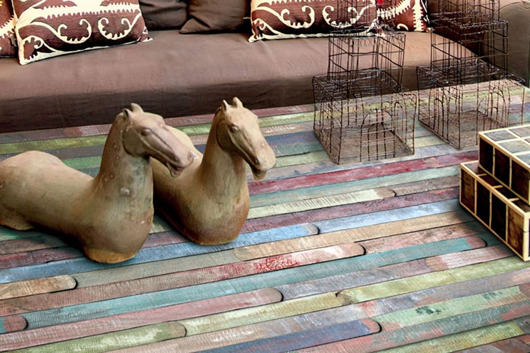 Dekorative Szene mit zwei Pferdefiguren, Metallkörben und Kisten auf einem Holzboden
