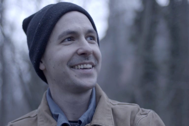 Porträt eines lächelnden Mannes mit Mütze und Jacke im Freien