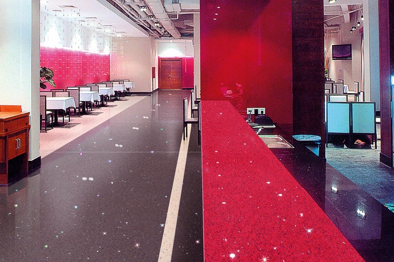 Restaurant mit Tischen und Stühlen sowie ein roter Tresenbereich mit Spüle