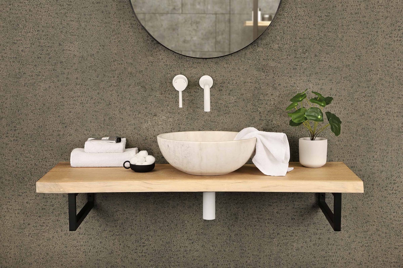 Badezimmerwaschbecken mit Spiegel, Armaturen, Ablage, Handtüchern und Pflanze