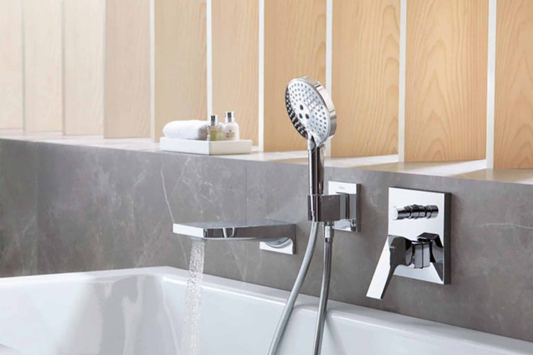 Badezimmer mit Badewanne, Armatur, Handbrause und Ablage