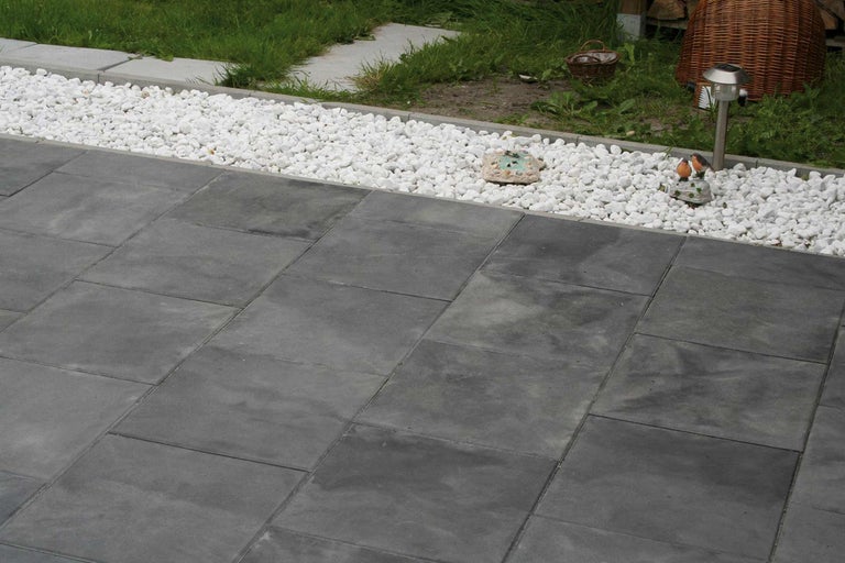 Garten mit grauen Terrassenplatten und weißem Zierkies