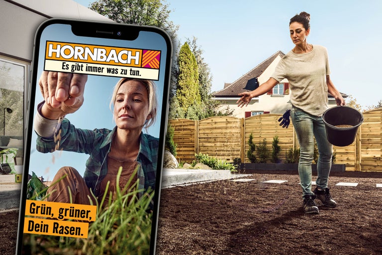 Eine Frau streut Rasensamen auf einem vorbereiteten Gartenboden. Im Vordergrund ein Smartphone mit der Hornbach App und dem Hornbach Firmenlogo.