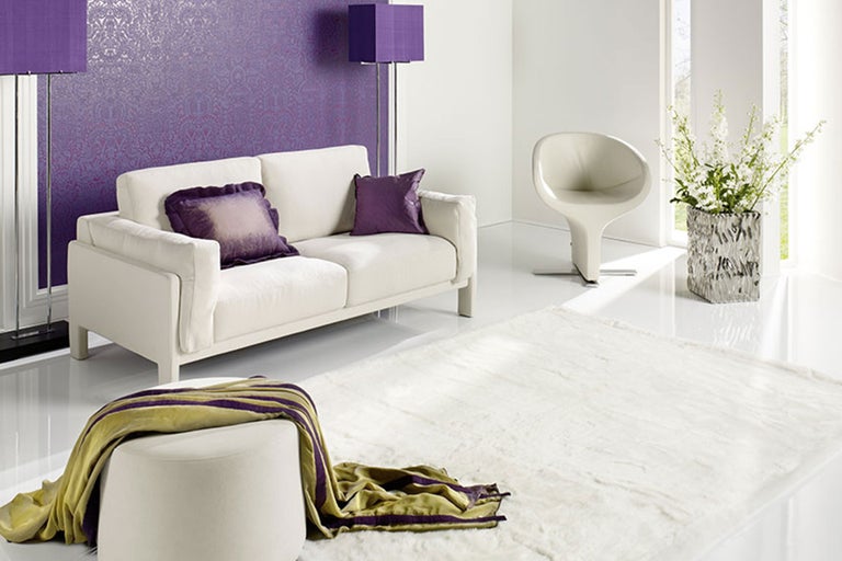 Helles Wohnzimmer mit Sofa, Sessel, Teppich, Hocker, Deckenleuchte und Stehlampe