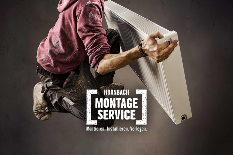 Ein Installateur hält einen Heizkörper. Hornbach Montageservice.