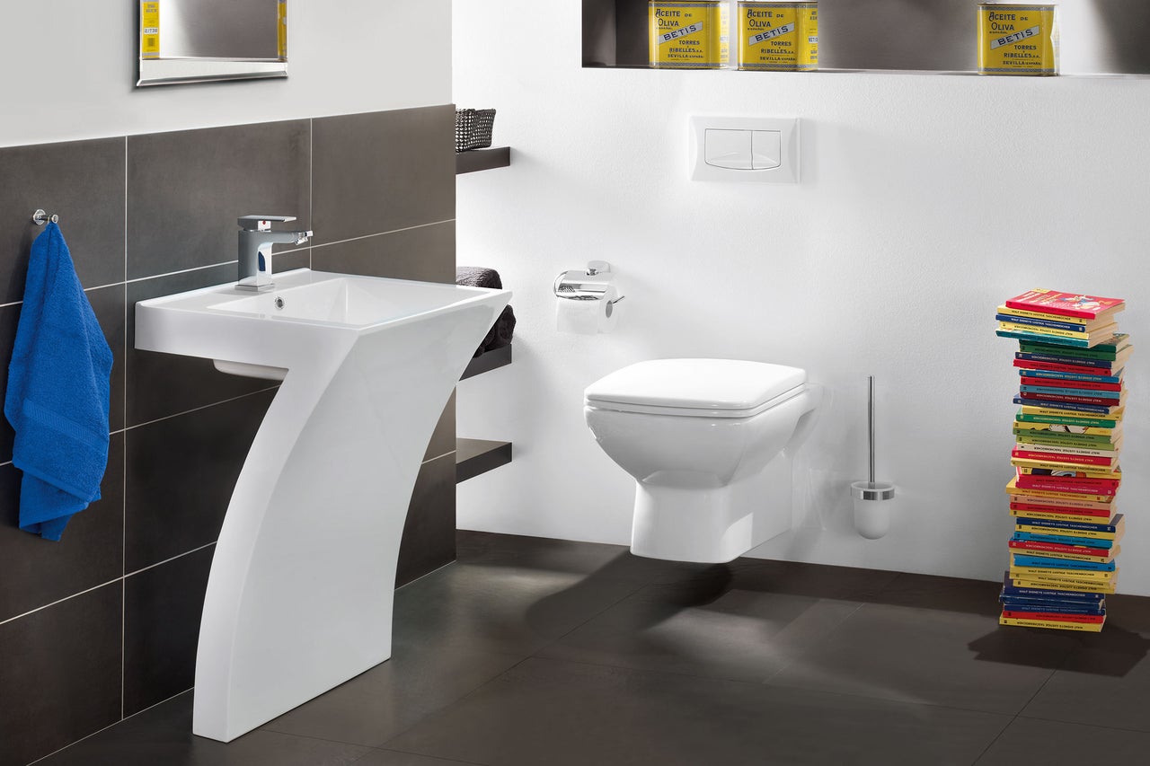 Badezimmer mit weißem Waschtisch, Toilette und Handtuch