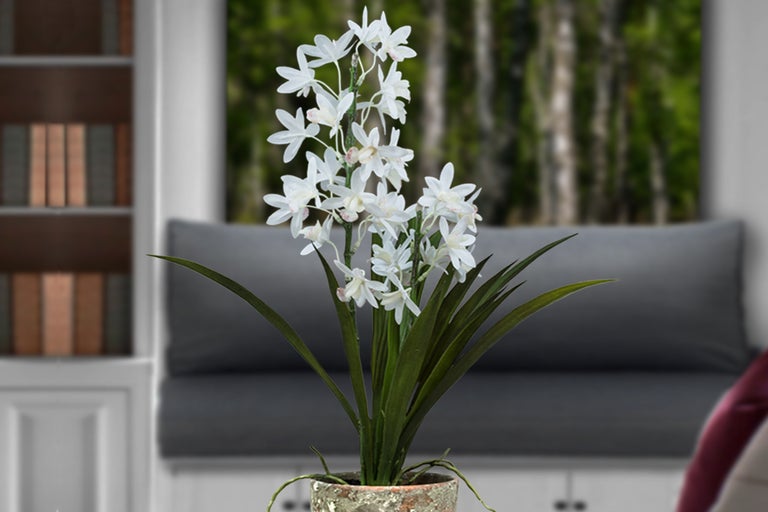 Dekorative Kunstblume mit weißen Blüten und grünen Blättern im Topf