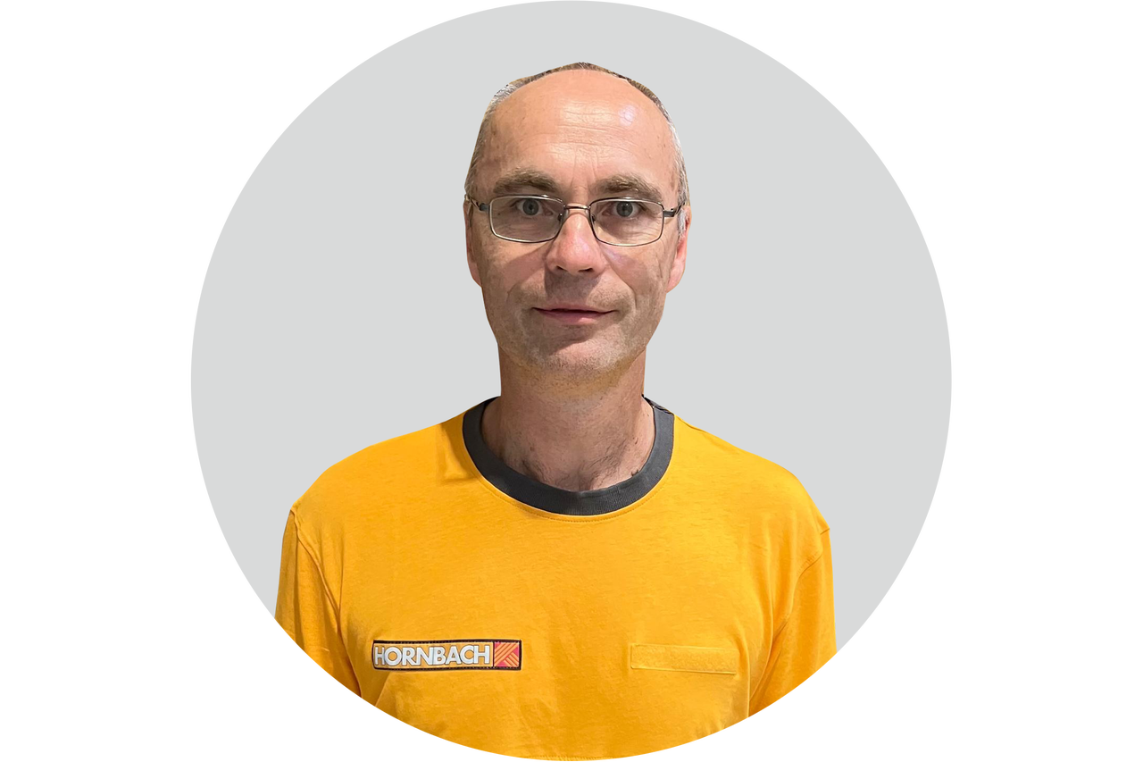 Hornbach Mitarbeiter mit Brille in einem gelben T-Shirt mit Hornbach Logo.