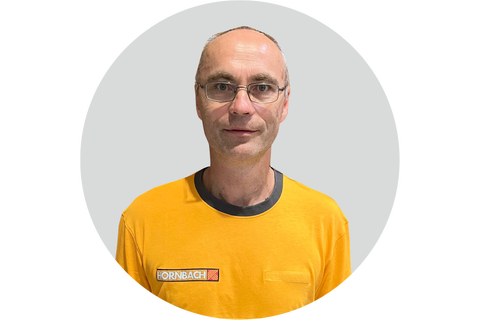 Hornbach Mitarbeiter mit Brille in einem gelben T-Shirt mit Hornbach Logo.