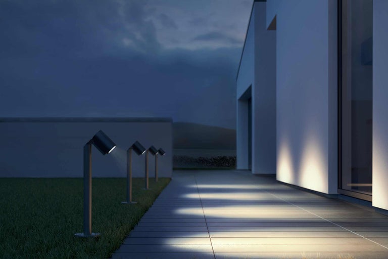 Außenbereich mit Rasenfläche, Terrasse und Gartenleuchten zur Beleuchtung des Weges an einem Gebäude