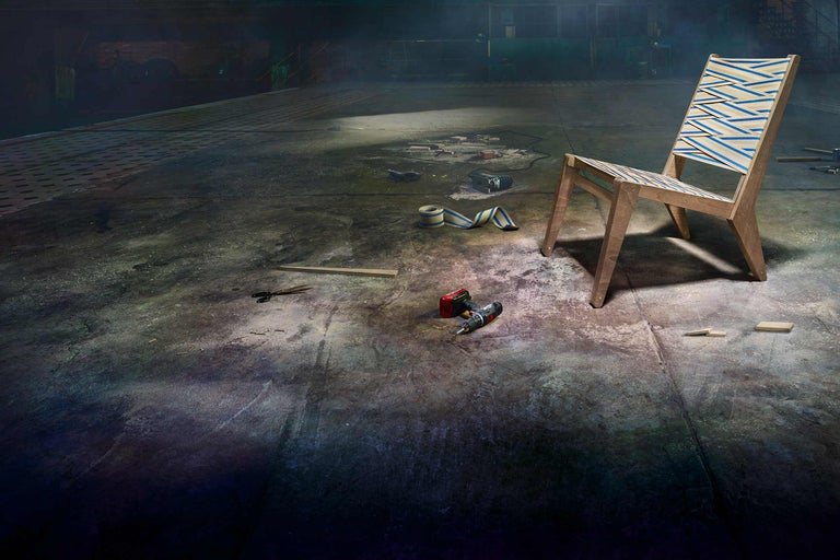 Holzstuhl mit Bandmuster und Werkzeugen in einer Werkstatt