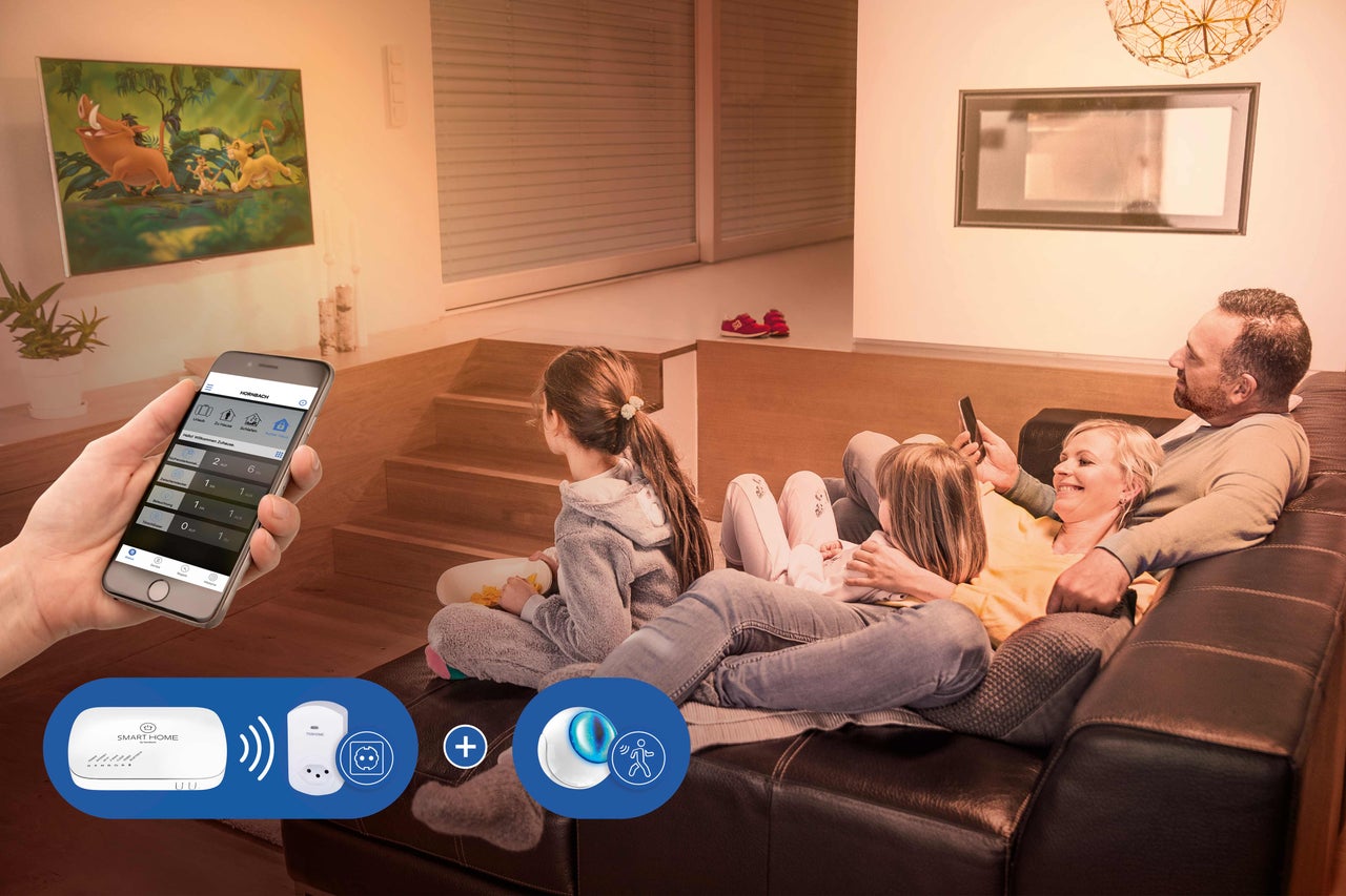 Familie entspannt im Wohnzimmer mit Smart Home Steuerung per App