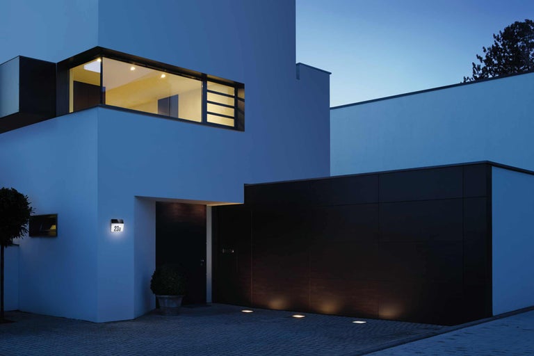 Beleuchtete Hausnummer an einer modernen Hausfassade bei Nacht