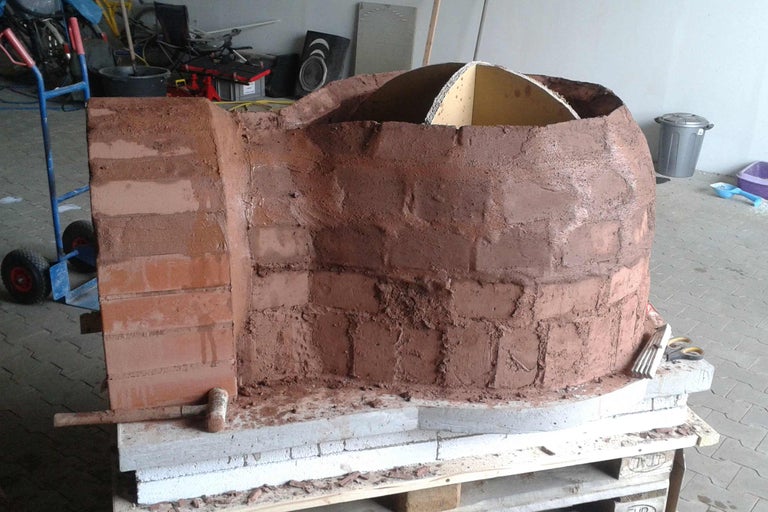 Gemauerter Pizzaofen auf einer Holzpalette