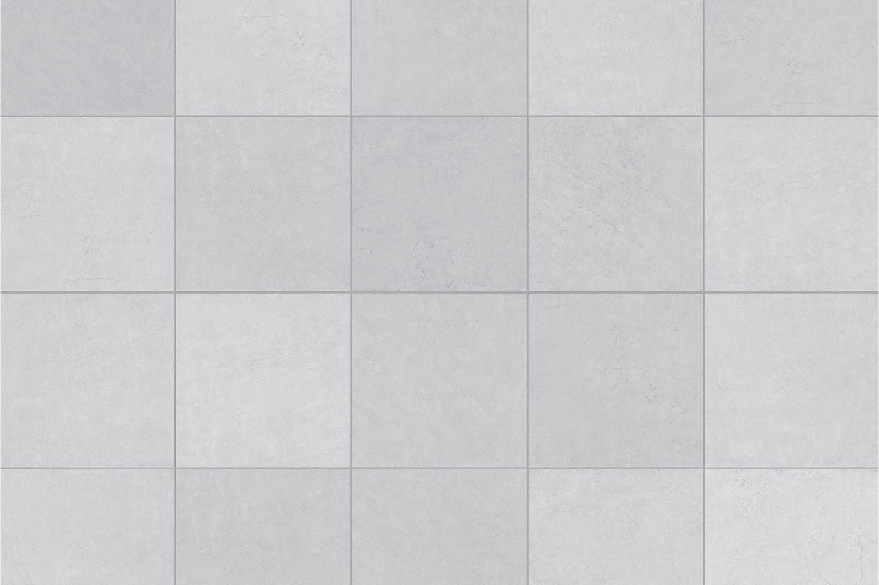 Quadratische Bodenfliesen mit dezenter Steinoptik in verlegter Ansicht.