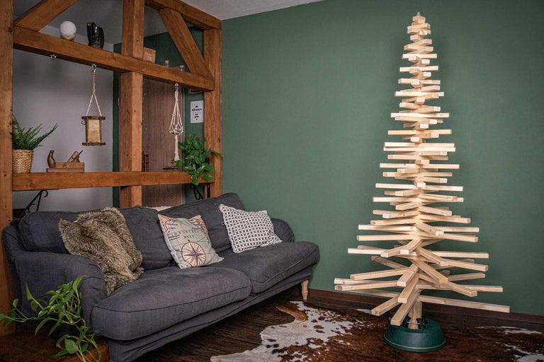 Dekoratives Wohnzimmer mit Sofa und hölzernem Tannenbaum