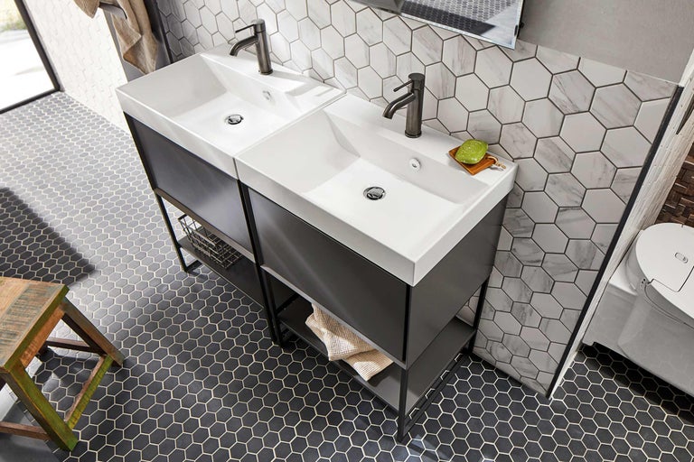 Badezimmer mit zwei Waschbecken, dunklen Unterschränken und sechseckigen Fliesen