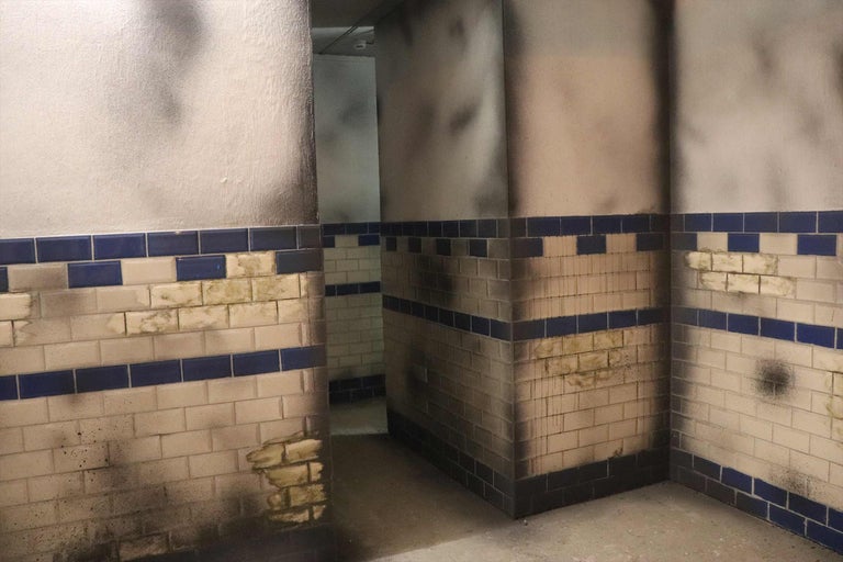 Detailaufnahme eines Raumes mit Wandfliesen und Farbschäden.