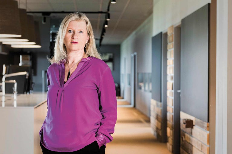 Porträt einer Frau in einem Bürogebäude mit Gang