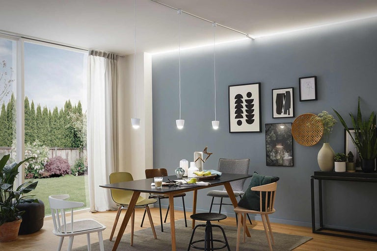 Esszimmer mit Esstisch, Stühlen, Pendelleuchten und Dekorationsgegenständen.