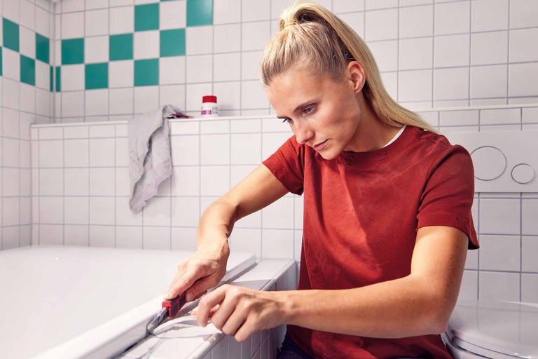 Reinigen einer Sockelleiste mit Spachtel und Tuch