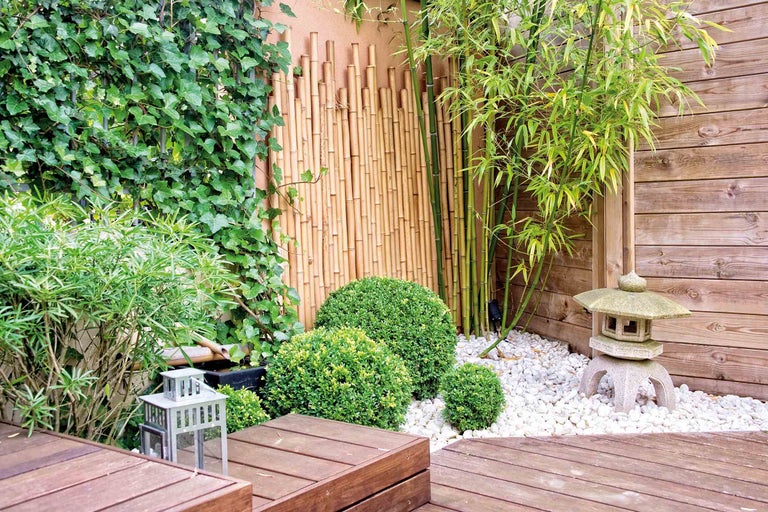 Gestalteter Garten mit Holzterrasse, Bambus, Steinlaterne und Kletterpflanzen