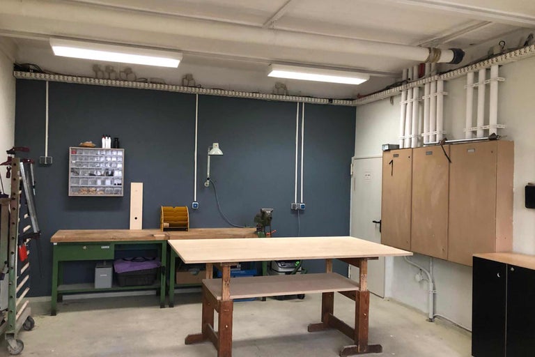 Werkstatt mit Werkbänken, Werkzeug und Beleuchtung