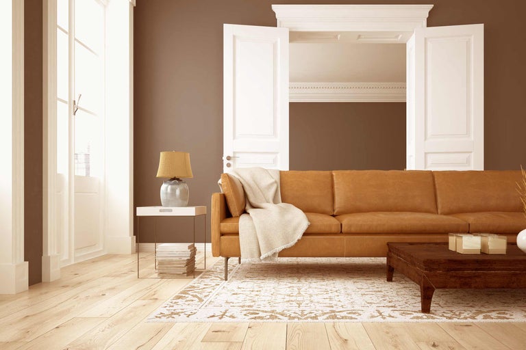 Wohnzimmer mit Ledersofa, Teppich und Holzboden