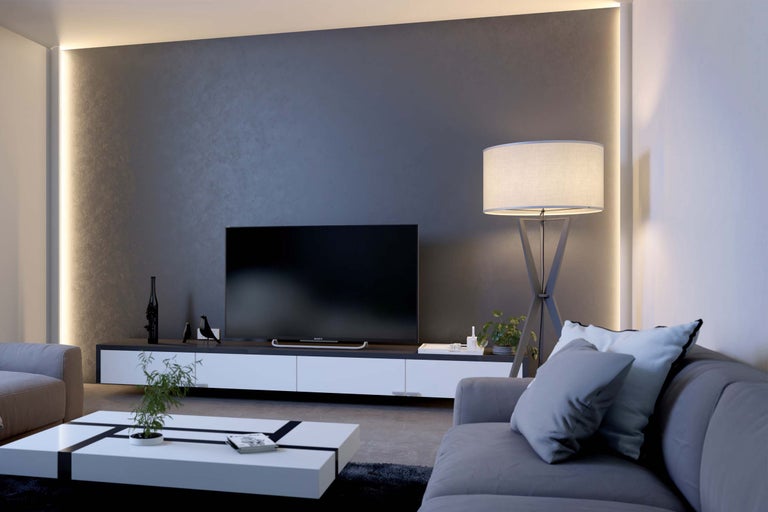 Wohnzimmer mit Sofa, Fernseher, Stehlampe und Couchtisch