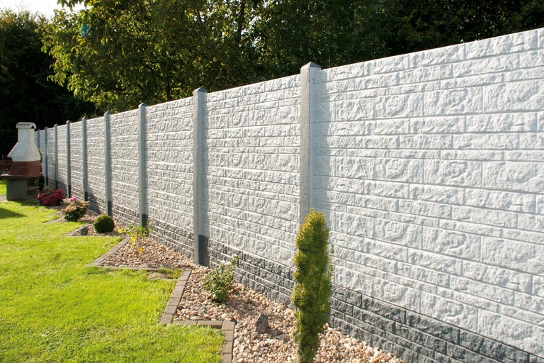 Garten mit Betonzaun in Steinoptik und Zaunpfosten
