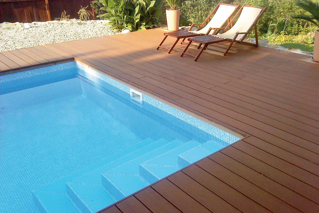 Pool mit Mosaikfliesen und Holzdeck mit Sonnenliegen