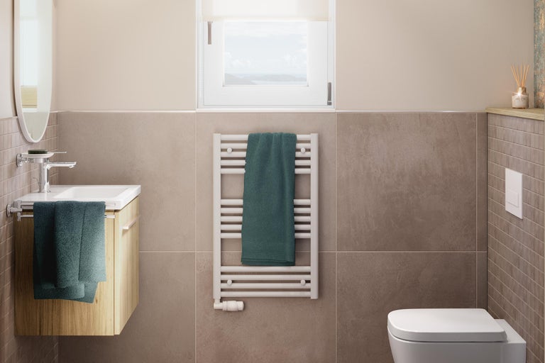 Helles Badezimmer mit Waschtisch, Heizkörper mit Handtuch und Toilette