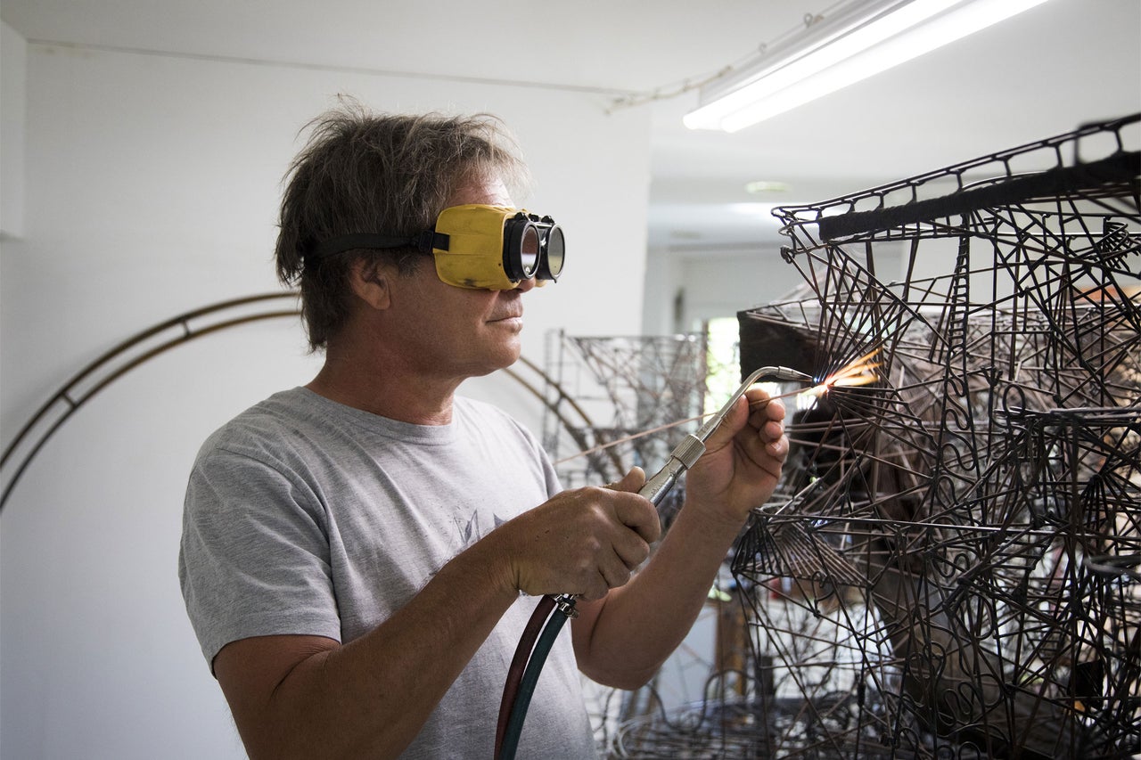 Mann mit Schweißbrille schweißt Metallkonstruktion