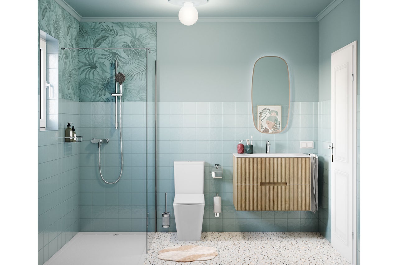 Modernes, helles Badezimmer mit bodengleicher Dusche, blauen Fliesen, Holz-Waschtischunterschrank und weißem Stand-WC auf Terrazzoboden.