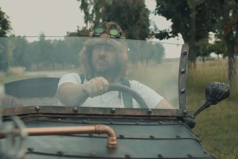 Mann mit Fellmütze und Schutzbrille fährt ein Fahrzeug im Steampunk-Stil