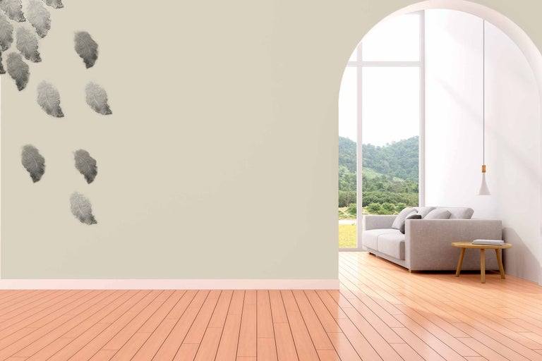 Wohnzimmer mit Feder Wandtattoo, Couch und Holzboden