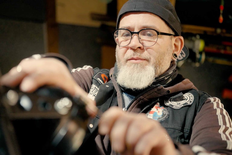 Mann mit Bart, Brille und Mütze montiert ein Produkt