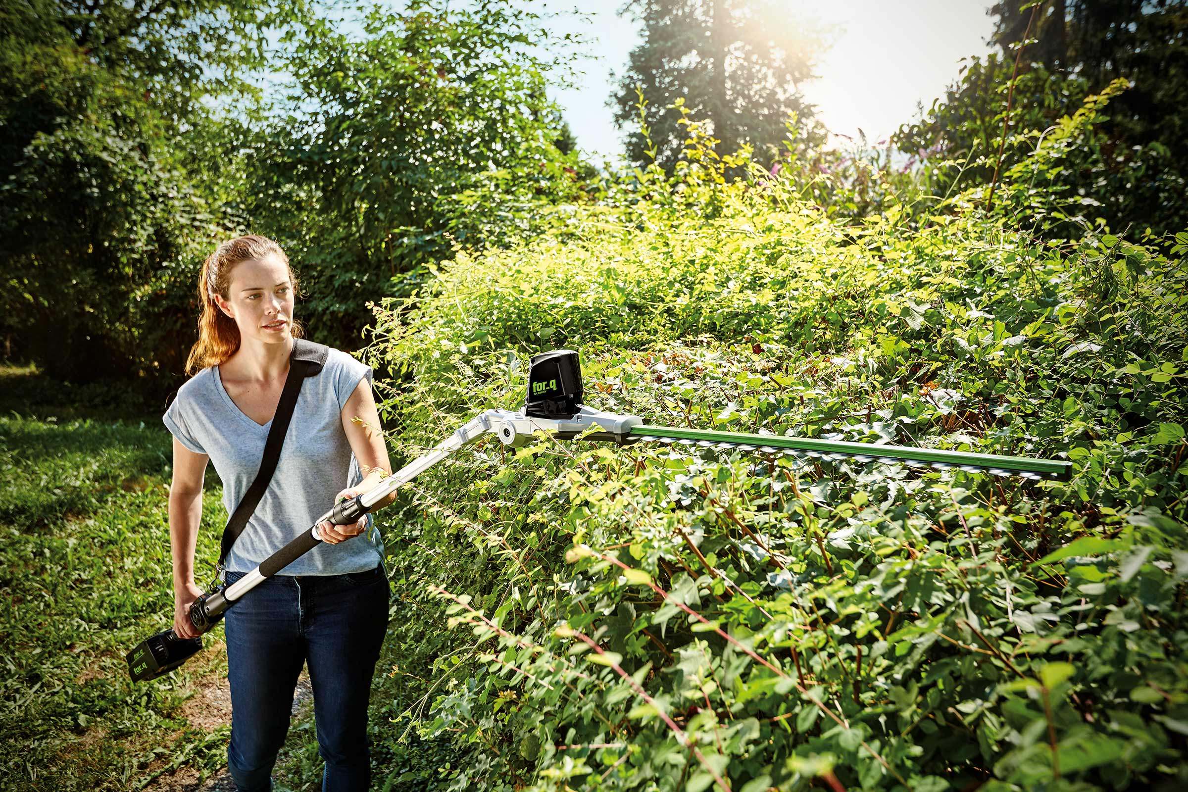 Frau schneidet Hecke mit einer Akku-Heckenschere.