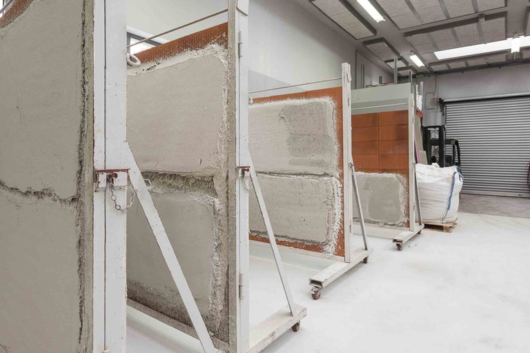 Reihe von Ziegelwänden mit Putz auf Metallgestellen