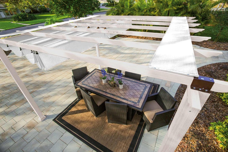 Pergola mit Sonnenschutz, Esstisch und Stühlen auf einer Terrasse