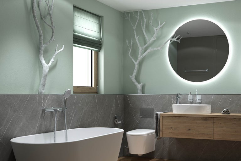 Modernes Badezimmer mit freistehender Badewanne, Wand-Toilette und Holz-Waschtisch. Ein rundum beleuchteter Spiegel und dekorative weiße Äste.